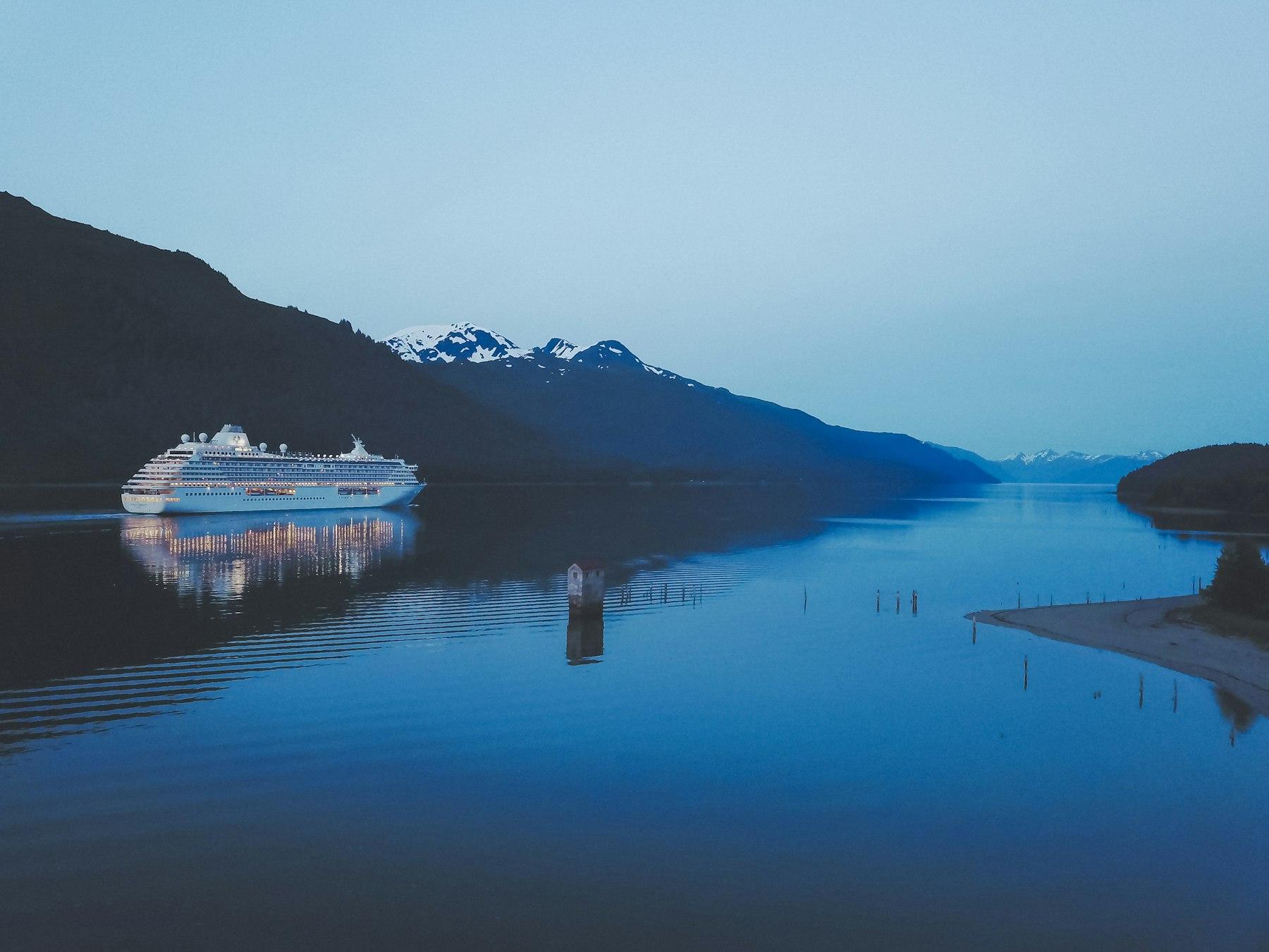 Cruiseschip in een stille fjord tijdens het blauwe uur