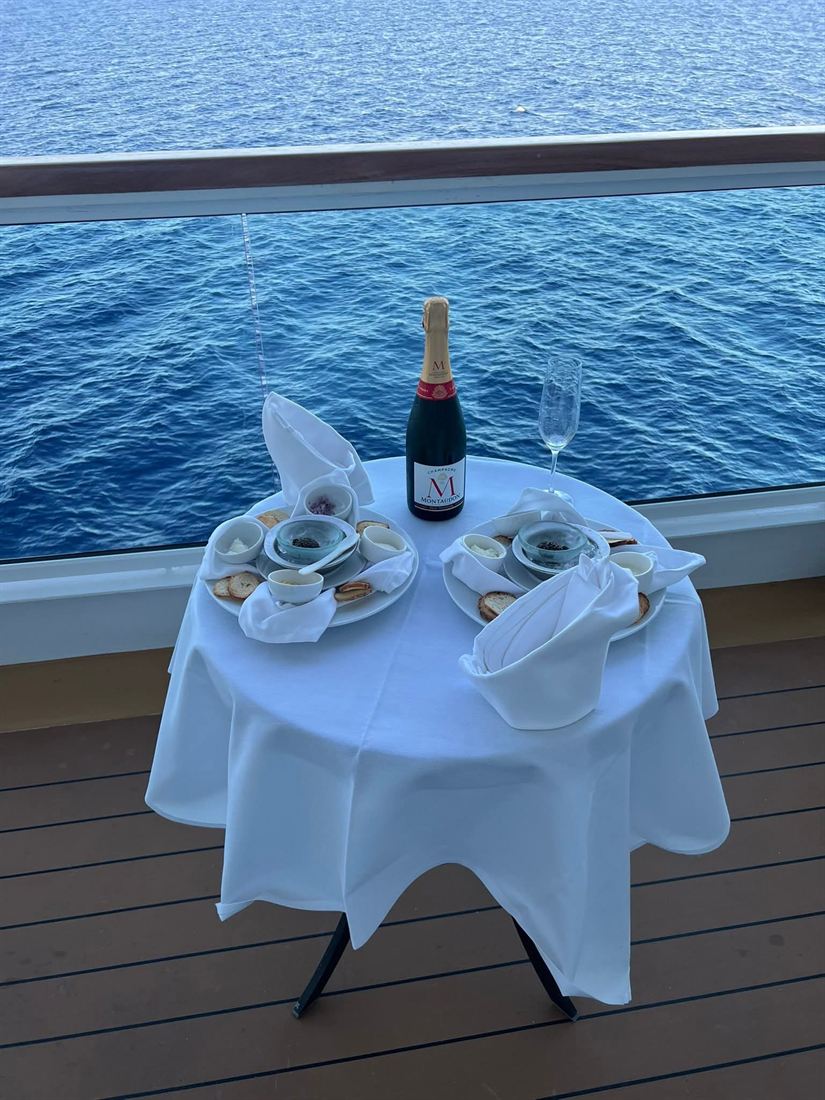 Champagne en hapjes op het balkon van een cruiseschip met zicht op zee