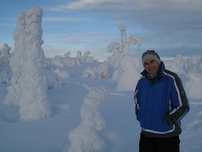 Yves tussen besneeuwde bomen in een winterlandschap